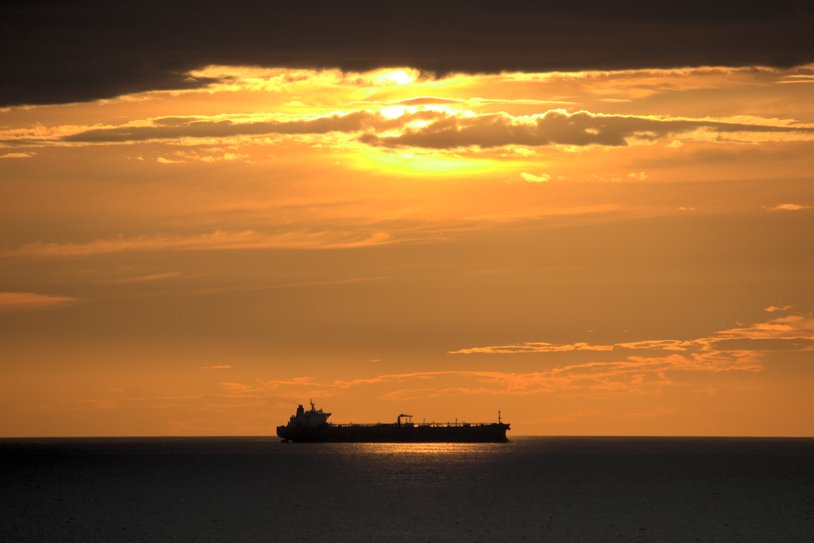 Cargo ship on the ocean under a golden evening sky